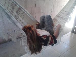 聖羅克迪米納斯的住宿－Pousada Sírius，躺在吊床上的年轻女孩