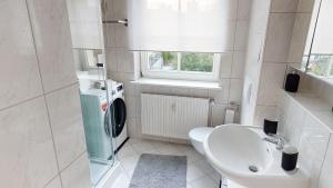 La salle de bains blanche est pourvue de toilettes et d'un lavabo. dans l'établissement Lieblingsapartment mit 2 Schlafzimmern - Nördliche Altstadt in Rostock, à Rostock