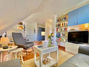 a living room with a couch and a tv at Strandnahe Ferienwohnung Rügen in Dranske