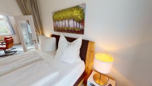 a bed with white pillows and a painting on the wall at Lieblingsapartment mit 2 Schlafzimmern - Nördliche Altstadt in Rostock in Rostock +7 photos