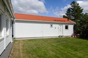 a white building with a red roof and a yard at Great Stay Guest House Sandviken in Sandviken