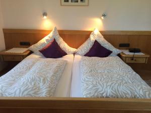ein Bett mit zwei nebeneinander liegenden Kissen in der Unterkunft Gästehaus Seeklause in Schwangau
