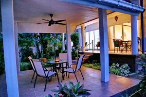 a patio with a table and chairs and a ceiling fan at Koh Chang 6 Bedroom Villa with Private Pool and Garden in Ko Chang