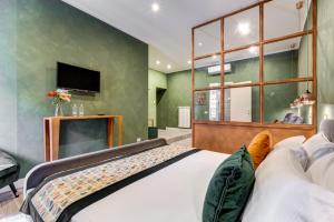 Un dormitorio con una cama grande y un televisor de pantalla plana. en Ripetta Luxurious Suites, en Roma
