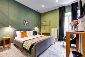 1 dormitorio con 1 cama y paredes verdes en Ripetta Luxurious Suites, en Roma