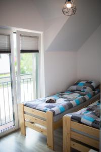 una camera da letto con letto con struttura in legno e finestra di Apartamenty Pasternik 7 SUCHEDNIÓW a Suchedniów