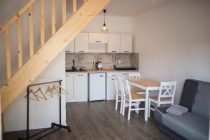 a kitchen and dining room with a table and a couch at Apartamenty Pasternik 7 in Suchedniów