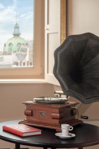 a table with an umbrella and a cup and suitcase at Chouchou Hotel in Paris