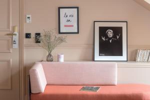 a living room with a pink couch and a picture at Chouchou Hotel in Paris