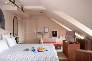 a bedroom with a bed with a tray of food on it at Chouchou Hotel in Paris