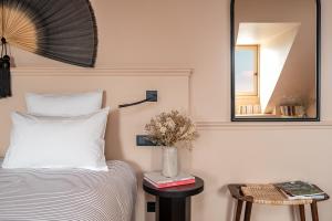 a bedroom with a bed and a mirror and a table at Chouchou Hotel in Paris
