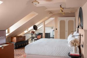 an attic bedroom with a bed and a desk at Chouchou Hotel in Paris