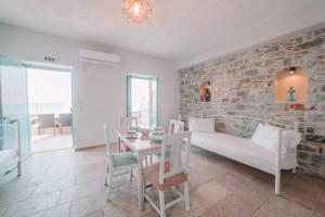 a room with a bed and a table and a brick wall at George SeaFront Suites in Neon Oitilon