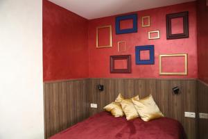 a bedroom with a red wall and a bed with pillows at Bienestar House in Blanes