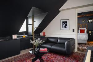 a living room with a black couch and a table at Chouchou Hotel in Paris