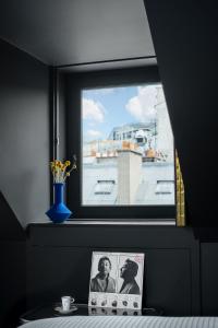 a window with a picture and a vase on a table at Chouchou Hotel in Paris