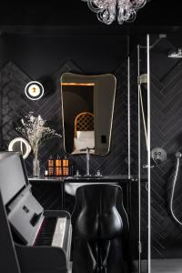 
a room with a chair and a mirror at Chouchou Hotel in Paris
