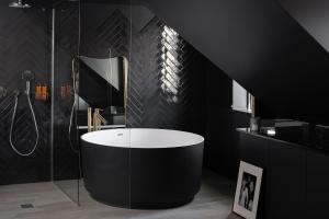 a black bathroom with a tub and a shower at Chouchou Hotel in Paris