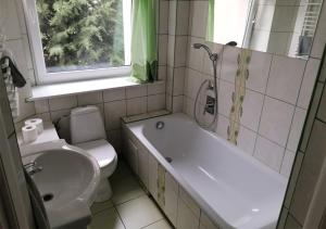 a bathroom with a tub and a toilet and a sink at Willa Mare Nostrum Gdynia - pokoje gościnne in Gdynia