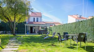 a yard with chairs and a table and a fence at Albergue San Anton in Melide