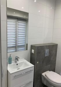 a white bathroom with a sink and a toilet at Willa Mare Nostrum Gdynia - pokoje gościnne in Gdynia