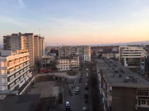 a city with buildings and a street with cars at Salonul Rosu in Bacău