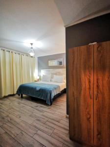 1 dormitorio con 1 cama y armario de madera en Doña Francisca en Arica