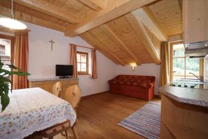 ein Wohnzimmer mit einem Tisch und einem Sofa in der Unterkunft Unterhabererhof in Santa Maddalena in Casies