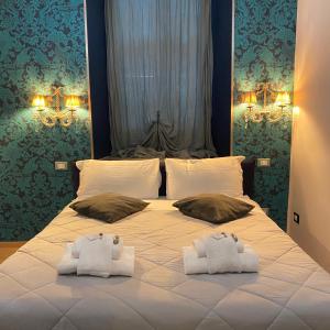 ein Schlafzimmer mit einem Bett mit zwei Handtüchern darauf in der Unterkunft St Peter Suites Boutique Music Guesthouse in Rom
