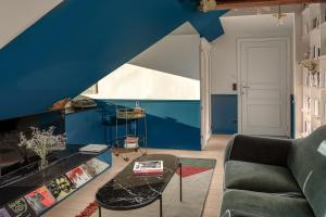 a living room with a couch and a blue wall at Chouchou Hotel in Paris