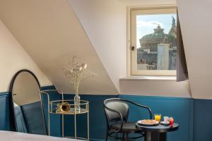 a room with a table and chairs and a window at Chouchou Hotel in Paris