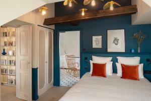 a bedroom with blue walls and a bed with orange pillows at Chouchou Hotel in Paris
