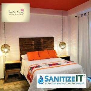 a bedroom with a bed with orange pillows and two lamps at Hotel Boutique Santa Lucía in Aquismón