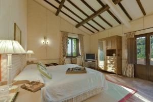 Un dormitorio con una cama grande y un televisor. en La Marrana - Castello del Terriccio, en Castellina Marittima