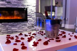 a table with red roses and a wine glass at Velmora Suites Bradford in Bradford
