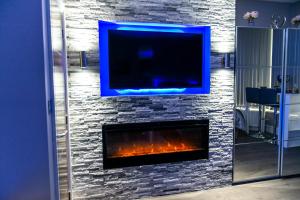 a living room with a fireplace with a tv above it at Velmora Suites Bradford in Bradford +125 photos