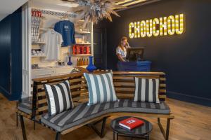 une femme debout dans un magasin avec un banc dans une pièce dans l'établissement Chouchou Hotel, à Paris