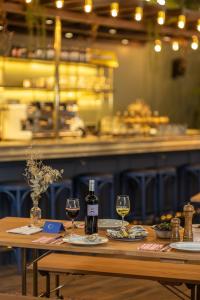 a wooden table with two glasses of wine on it at Chouchou Hotel in Paris