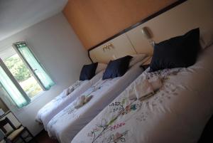 - 2 lits installés l'un à côté de l'autre dans une chambre dans l'établissement Hôtel Myosotis, à Lourdes