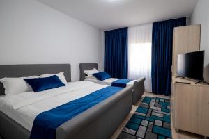 um quarto com uma cama grande e uma televisão em Hotel Simona em Bucareste