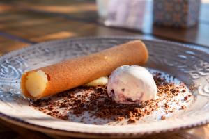 a plate with a cinnamon roll and ice cream on it at Parosland Hotel in Aliki
