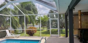 a screened in porch with a view of a pool at Sunny Paradise in Cape Coral