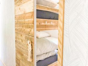 1 dormitorio con pared de madera junto a la cama en STOERbuiten lodge Les Charmes en Pech Sec