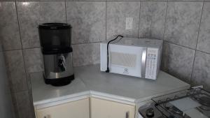 uma cozinha com comodidades para preparar café e um micro-ondas em Edifício Belio em Cascavel