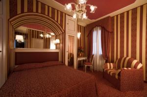 a bedroom with a bed and a chair and a mirror at Hotel Alcyone in Venice
