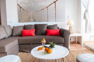 uma sala de estar com um sofá e uma mesa com laranjas em Apartamento Ferrera Park 505 em Cala Ferrera