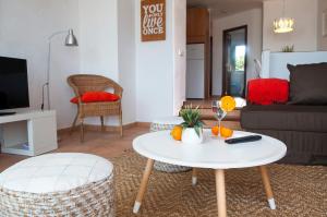 ein Wohnzimmer mit einem weißen Tisch und einem Sofa in der Unterkunft Apartamento Ferrera Park 505 in Cala Ferrera
