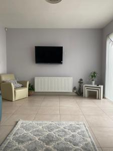 a living room with a flat screen tv on a wall at Westerlies in Portrush
