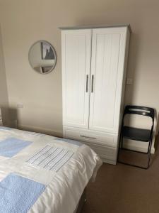 a bedroom with a bed and a dresser and a mirror at Westerlies in Portrush