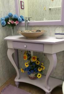 un mobile bagno con lavabo e fiori di B&B 091 a Palermo Altre 37 foto